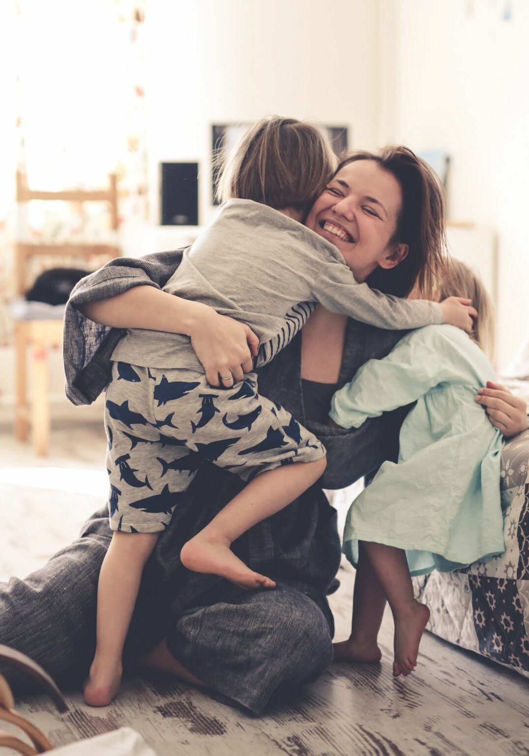 happy mom with two children on the floor in the room. concept motherhood and trust, toning and life style