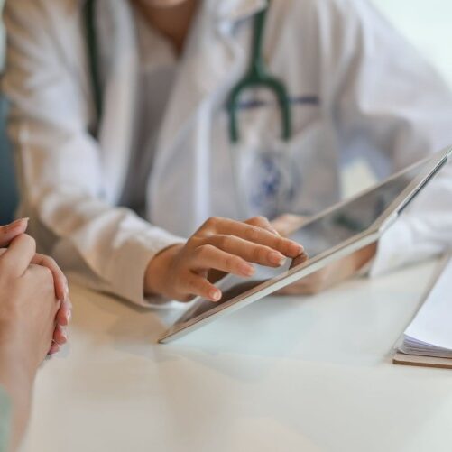 Shot of a doctor showing a patient some information on a digital tablet